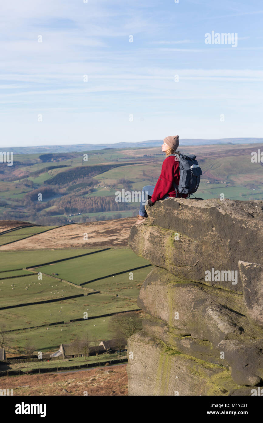 Regno Unito, Derbyshire, Peak District Nationa Park, un camminatore seduta ammirando la vista dal bordo Stanage. Foto Stock