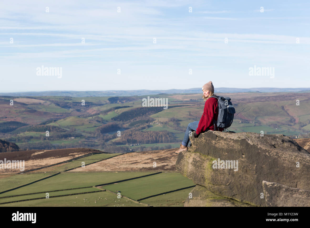 Regno Unito, Derbyshire, Peak District Nationa Park, un camminatore seduta ammirando la vista dal bordo Stanage. Foto Stock