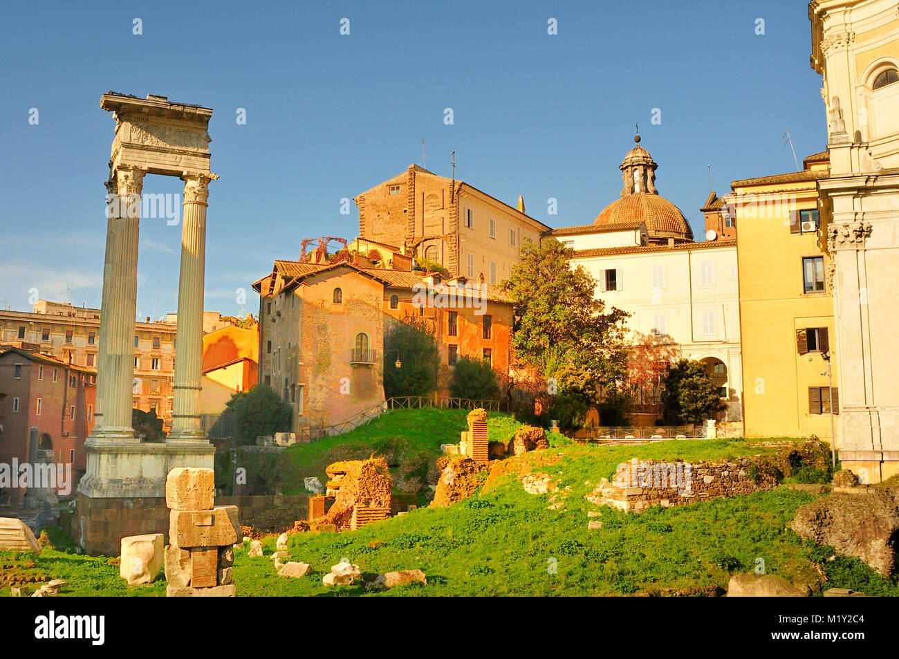 Antichi e moderni edifici con le rovine e i pilastri su via San Marco, Roma Foto Stock