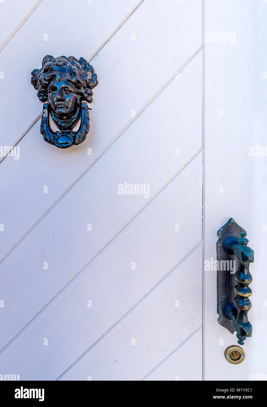 Frammento di bianco vecchia porta di legno con la donna-testa conformata respingente Foto Stock