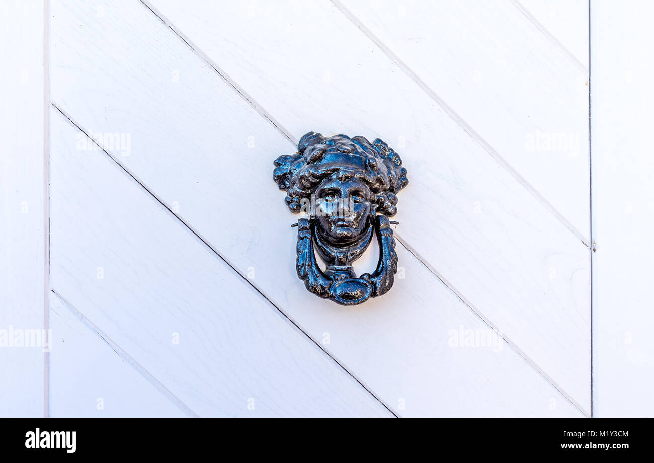 Frammento di bianco vecchia porta di legno con la donna-testa conformata respingente Foto Stock
