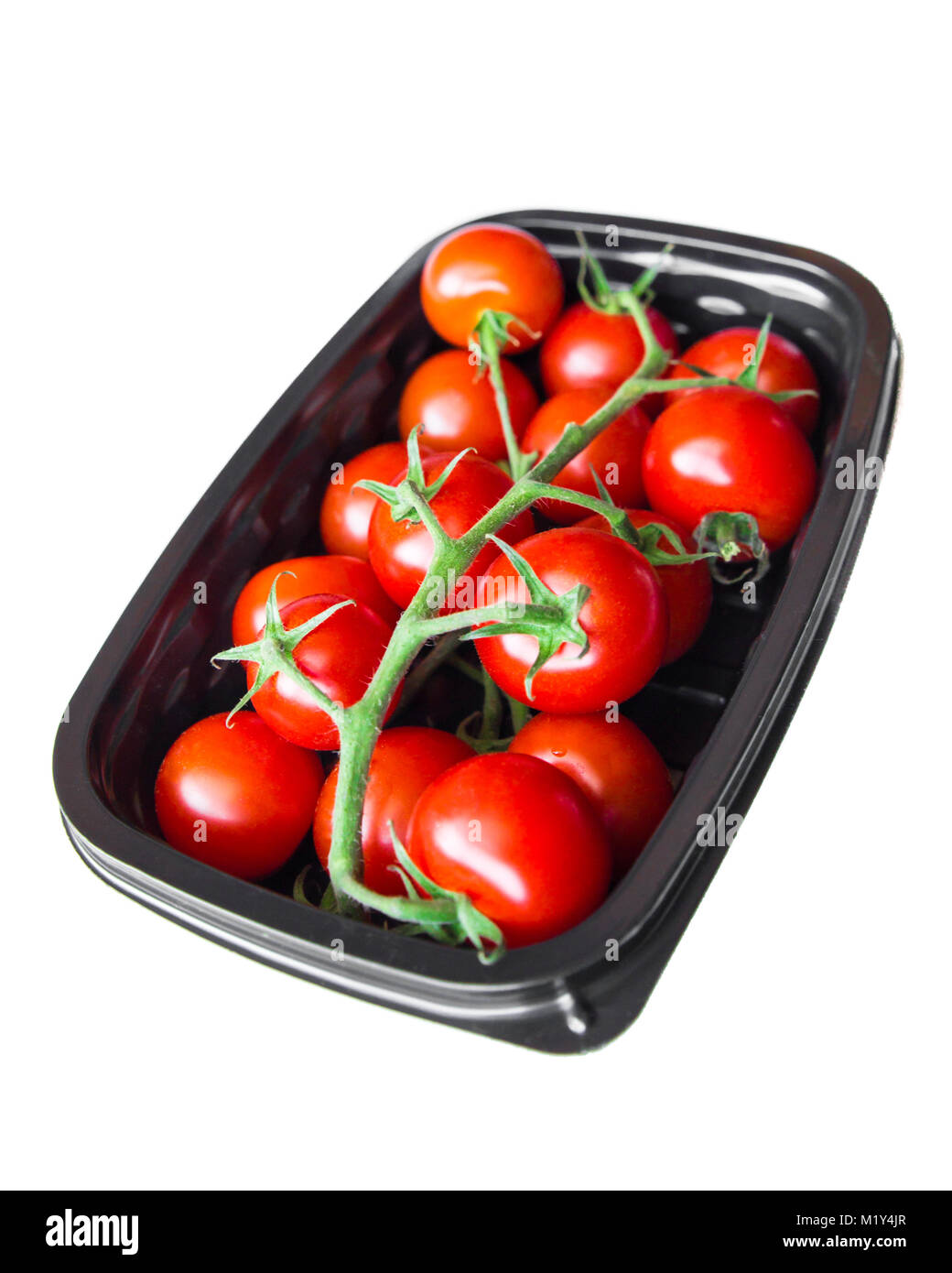 Ciliegia matura i pomodori in contenitore di plastica contro uno sfondo bianco Foto Stock