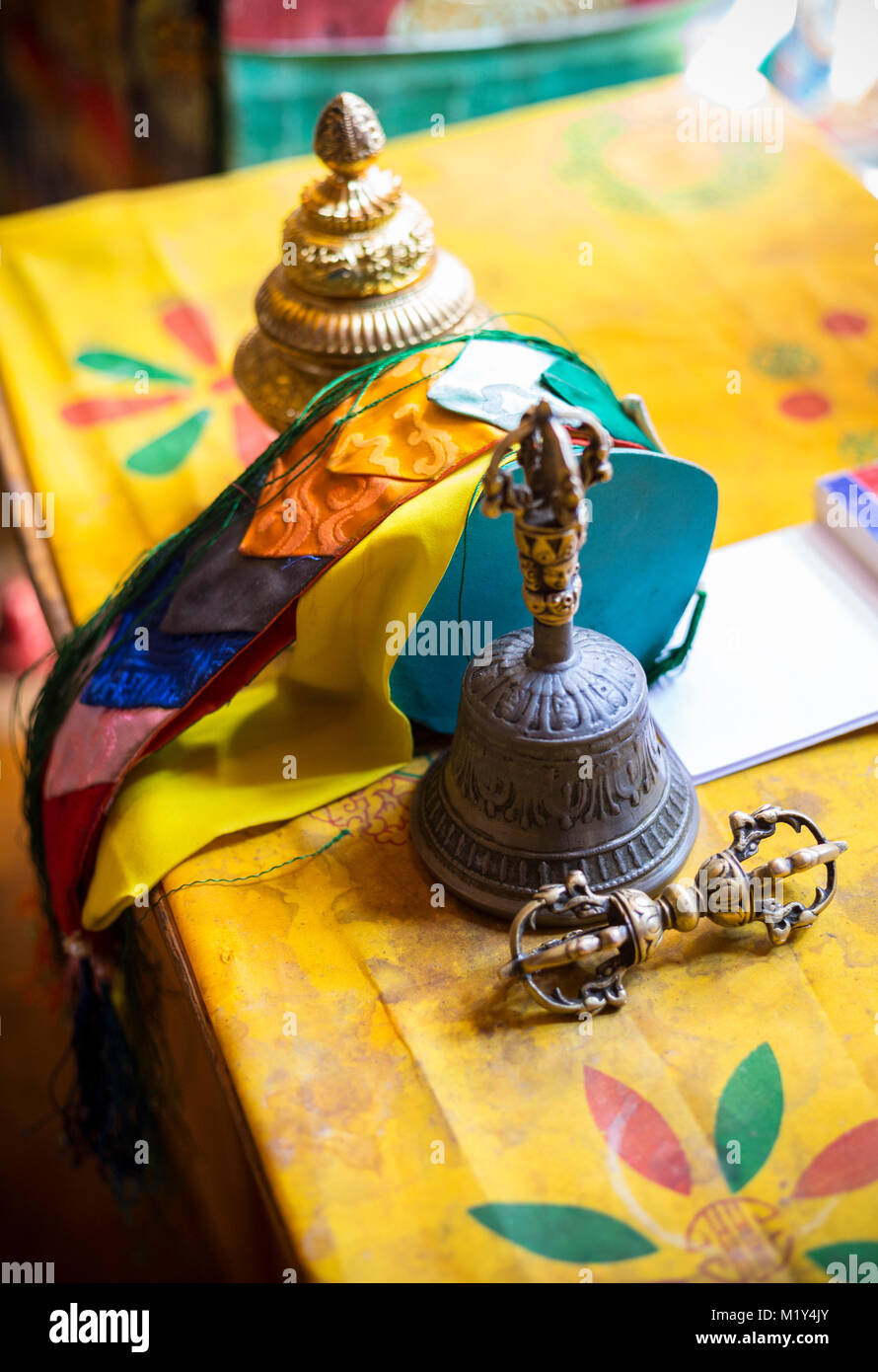Paro, Bhutan. Monk's Vajra (Dorje) (attrezzatura che simboleggia la compassione e abile significa), campana, nastri e bruciatore di incenso sulla sua scrivania nel tempio. Foto Stock