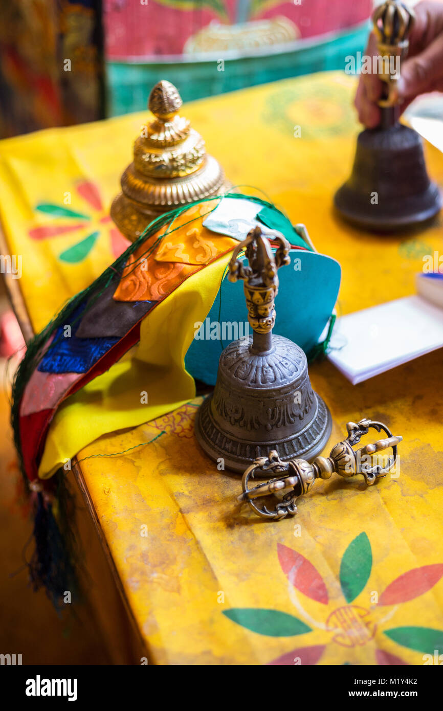 Paro, Bhutan. Monk's Vajra (Dorje) (attrezzatura che simboleggia la compassione e abile significa), campana, nastri e bruciatore di incenso sulla sua scrivania nel tempio. Foto Stock