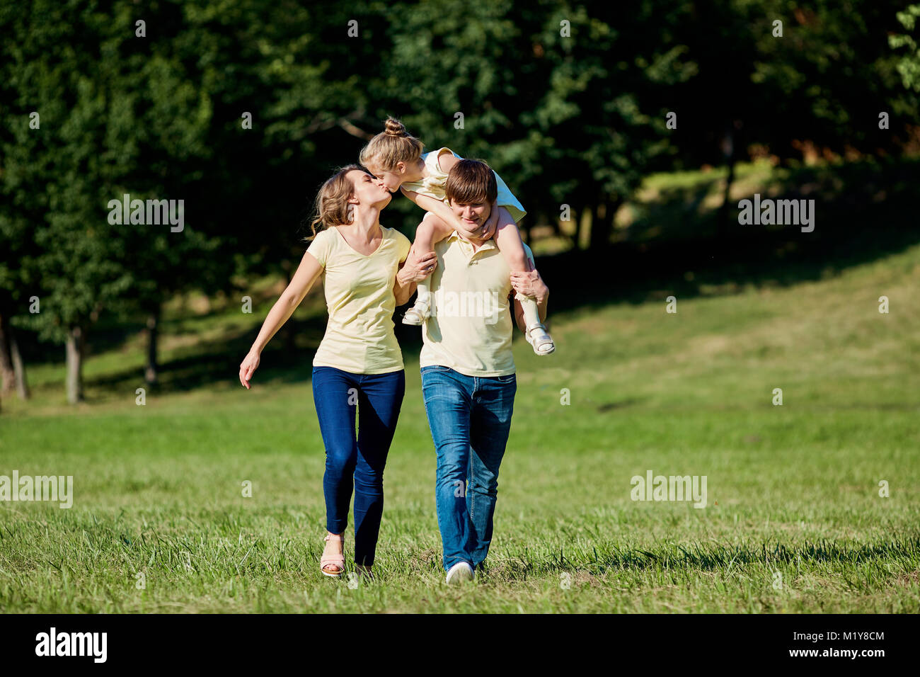 La famiglia felice passeggiate nel parco in estate Foto Stock
