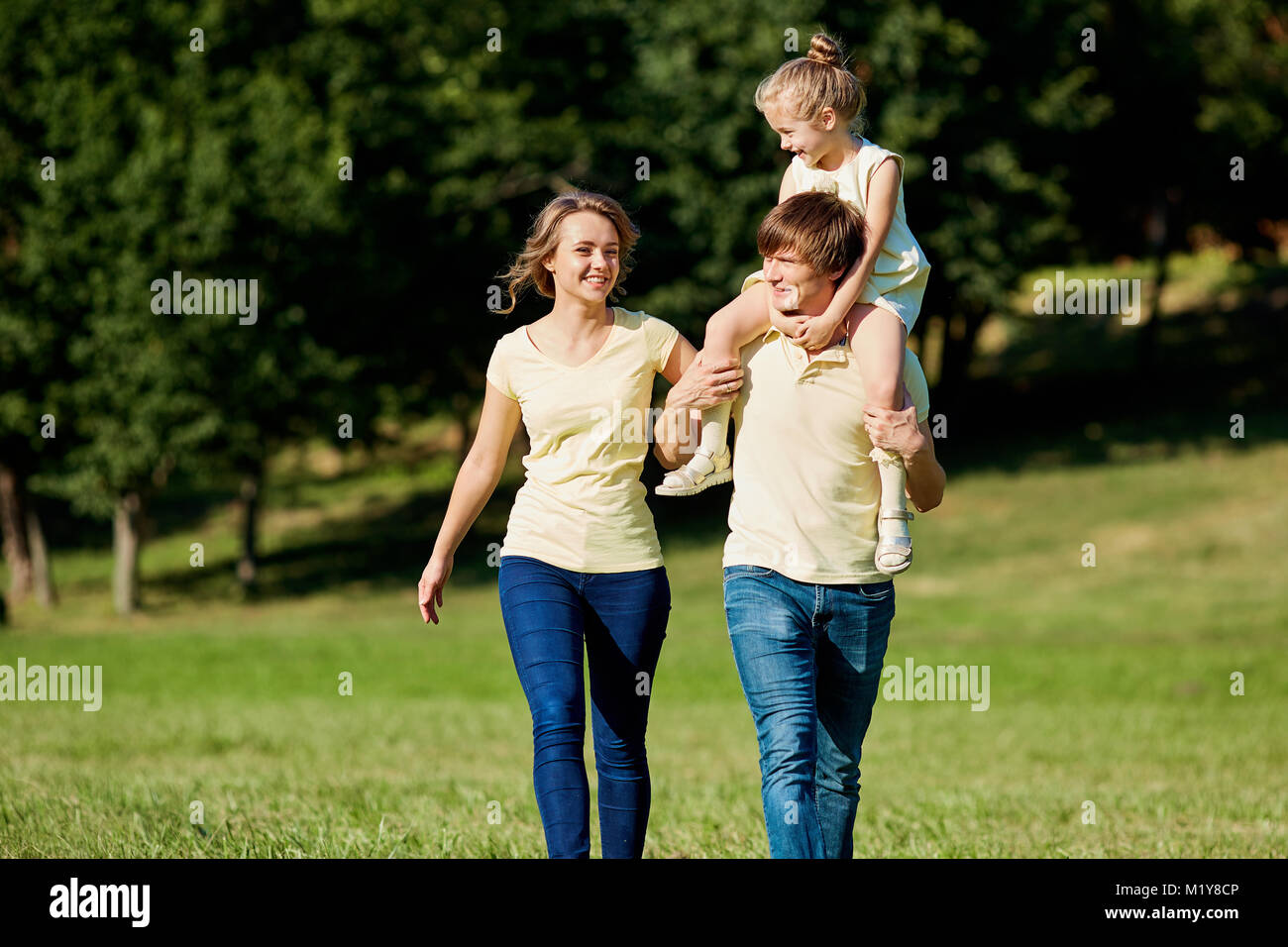 La famiglia felice passeggiate nel parco in estate Foto Stock