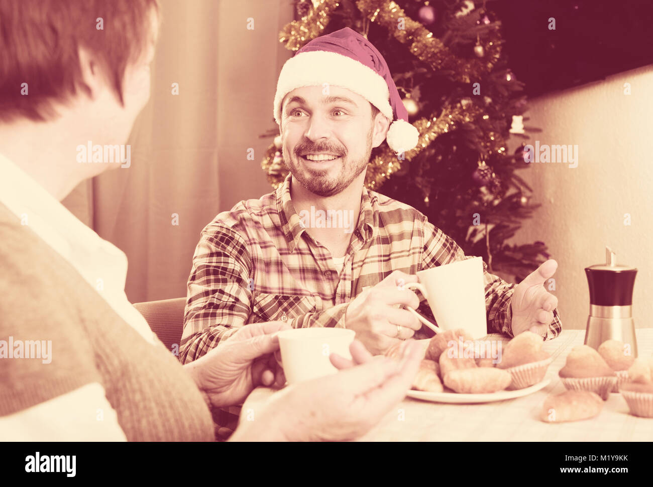 Sorridente madre e figlio adulto trascorrere il Natale insieme a casa Foto Stock