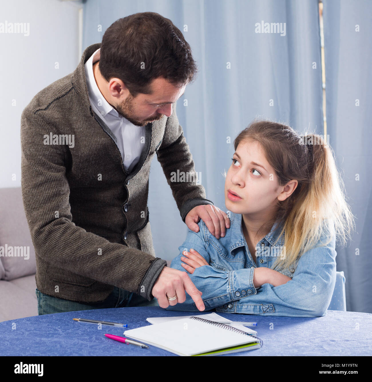 Padre aiutando il suo bambino a fare i compiti a casa Foto Stock