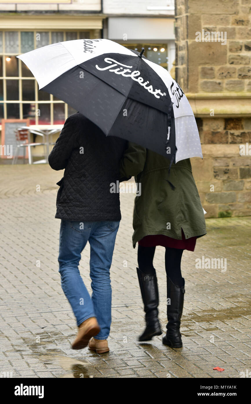 Un paio di passeggiate in piogge pioggia battente la condivisione di un  grande bianco e nero golf ombrello. Amanti sotto un ombrello stare insieme  nella tempesta di pioggia Foto stock - Alamy