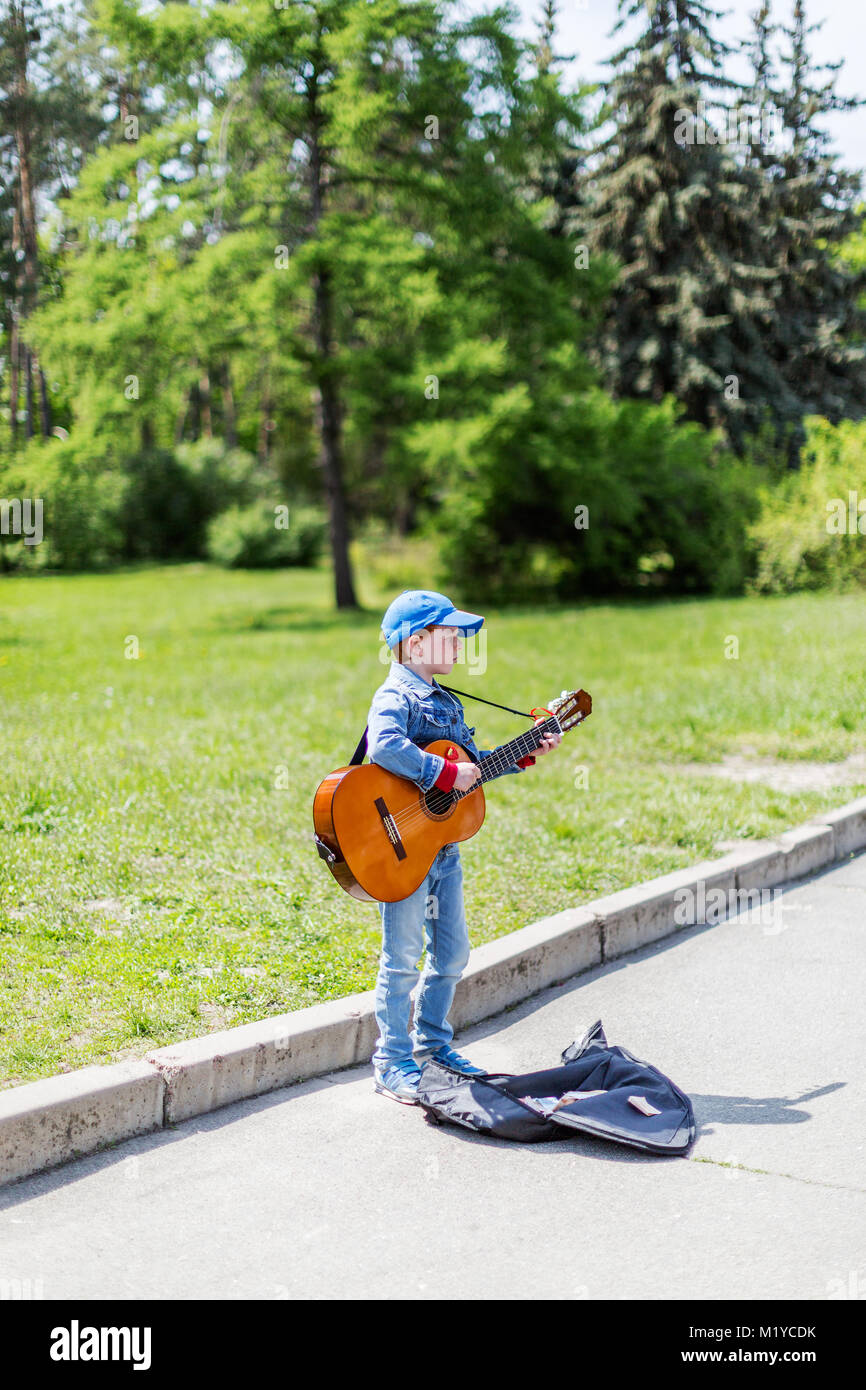 Kiev, Ucraina Maggio 01, 2016. Ragazzo giocando sulla chitarra acustica all'esterno. Poco musicista di strada Foto Stock