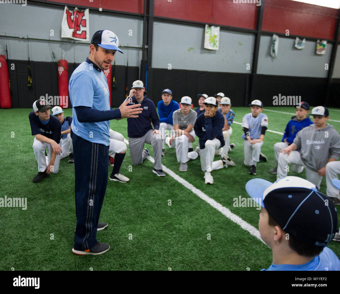 Il baseball coach parlando con i giocatori di allenamento indoor facility in New Jersey Foto Stock