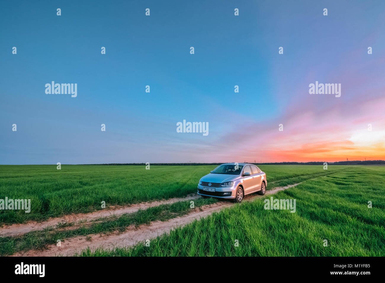 Dobrush, Bielorussia - 27 Maggio 2017: bella vista da una Volkswagen Polo vento in un campo estivo al tramonto Foto Stock