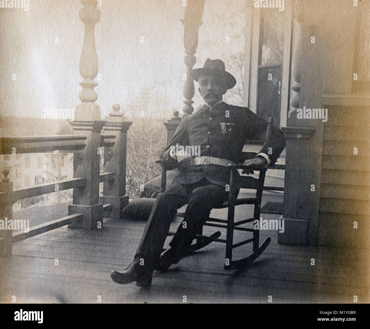 Antique circa 1905 fotografia, anziano gentiluomo sul suo portico in uniforme militare con badge GAR. Posizione sconosciuta, probabilmente la Nuova Inghilterra, Stati Uniti d'America. Ho più foto di questa famiglia a Riggsville (ora Robinhood), Maine in Sagadahoc County, Stati Uniti d'America. Foto Stock