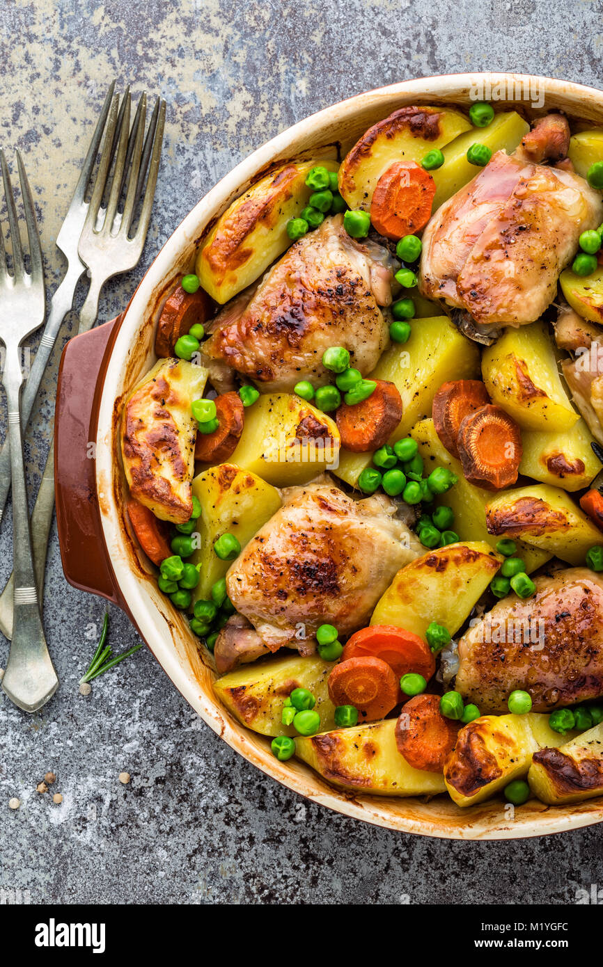 Carne di pollo Cosce, al forno con patate, carote e piselli verdi Foto  stock - Alamy