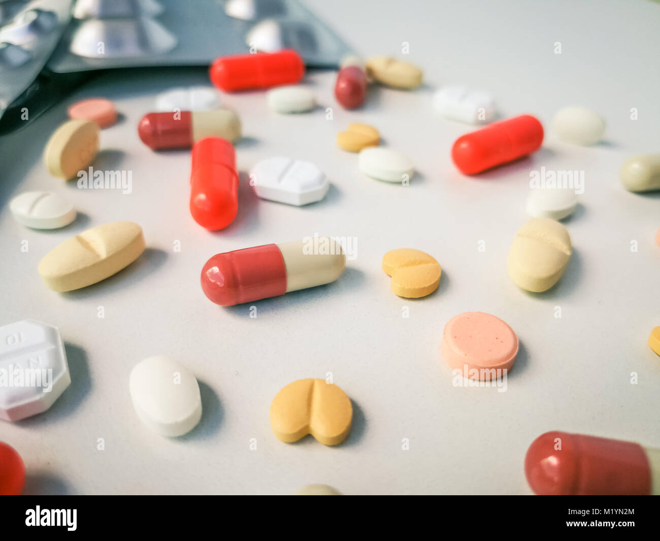 Bianco di medicazione e compresse colorati disposti astratto bianco su sfondo colorato. capsule pillole per il design. Salute, trattamento, scelta lifesty sani Foto Stock