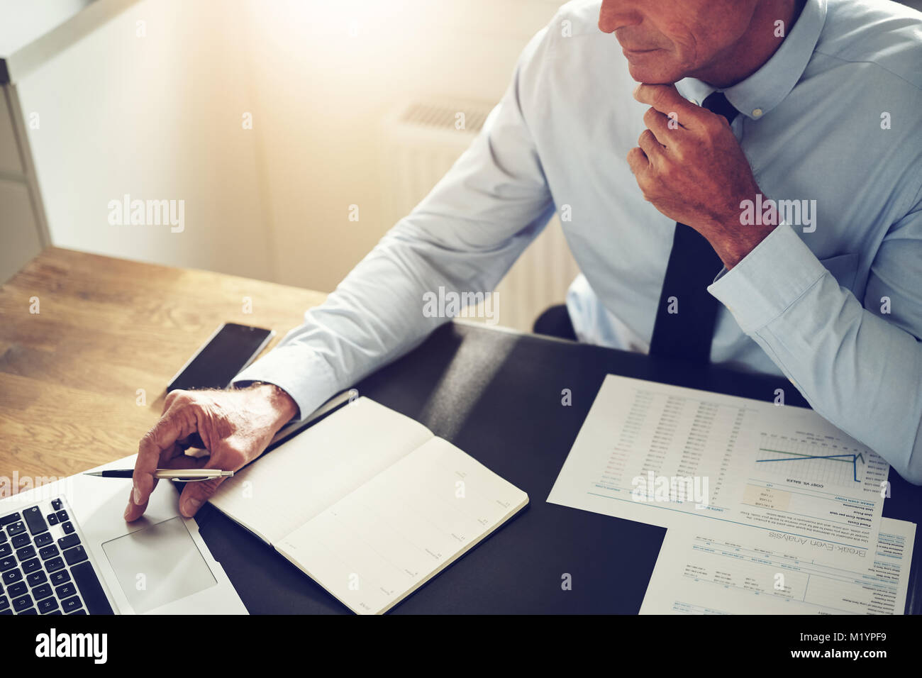 Coppia pianificatore finanziario seduto alla sua scrivania in un ufficio a lavorare online con un computer portatile e di andare oltre i documenti Foto Stock Coppia pianificatore finanziario seduto alla sua scrivania in un ufficio a lavorare online con un computer portatile e di andare oltre i documenti Foto Stock