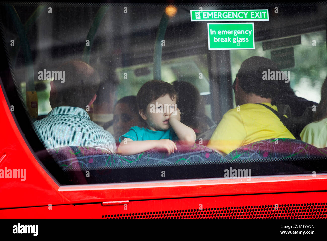 Londra, Inghilterra - Agosto 22, 2017 Un ragazzo di quattro guarda il finestrino posteriore di un autobus Foto Stock