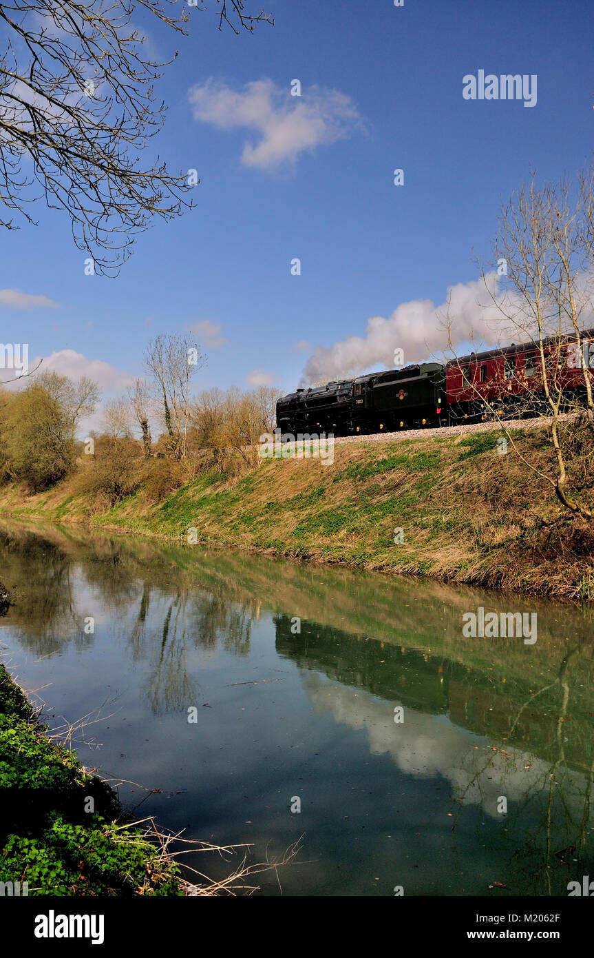 L'acqua ferma del canale Kennett & Avon riflette la norma BR n. 70013 'Oliver Cromwell' in quanto si dirige verso ovest con il suo pullman di supporto, il 4th aprile 2009. Foto Stock
