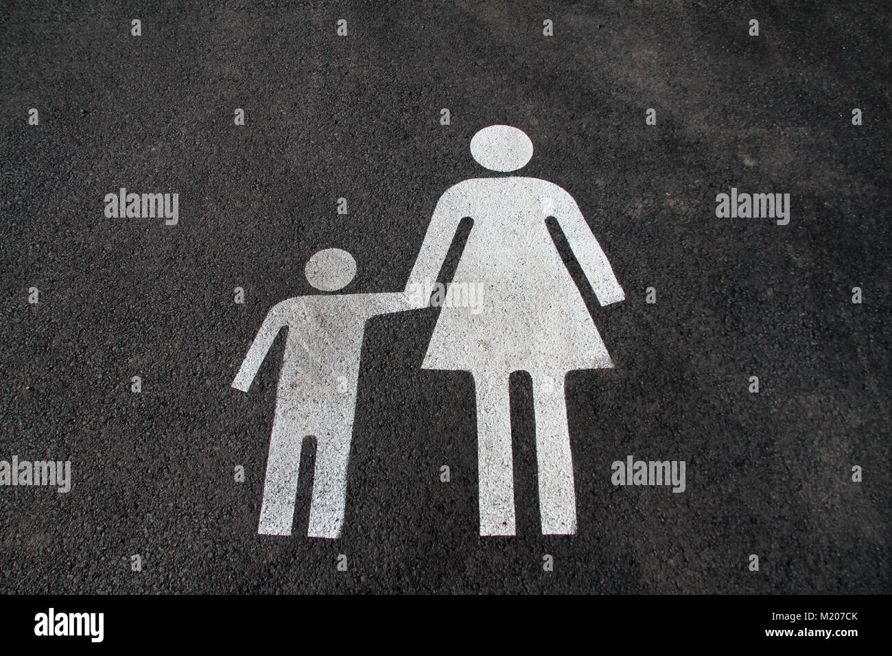 Lo spazio di parcheggio per le madri e i bambini. Segno su asfalto "madre e bambino". Segno sulla strada "mamma e bambino". Segnale pedonale su asfalto. Parcheggio spac Foto Stock