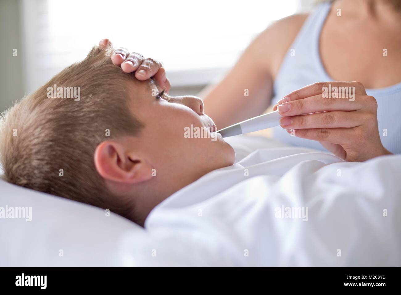 Ragazzo avente la sua temperatura prese. Foto Stock