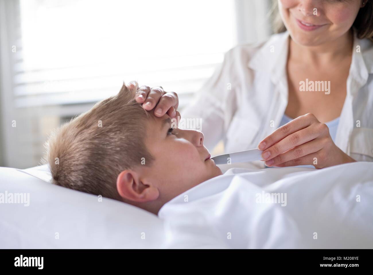 Ragazzo avente la sua temperatura prese. Foto Stock