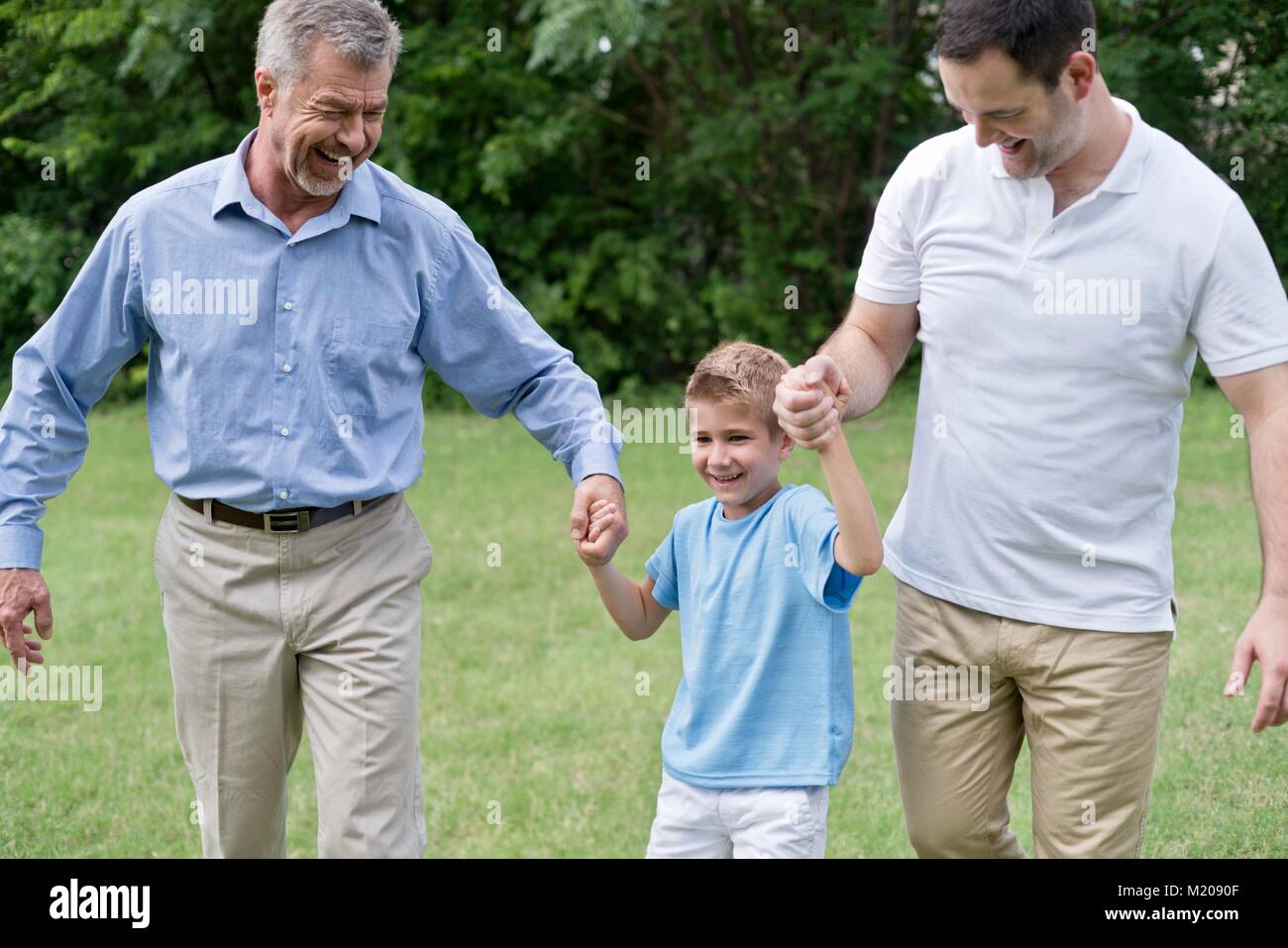 Nonno, il padre del ragazzo e tenendo le mani e sorridente. Foto Stock