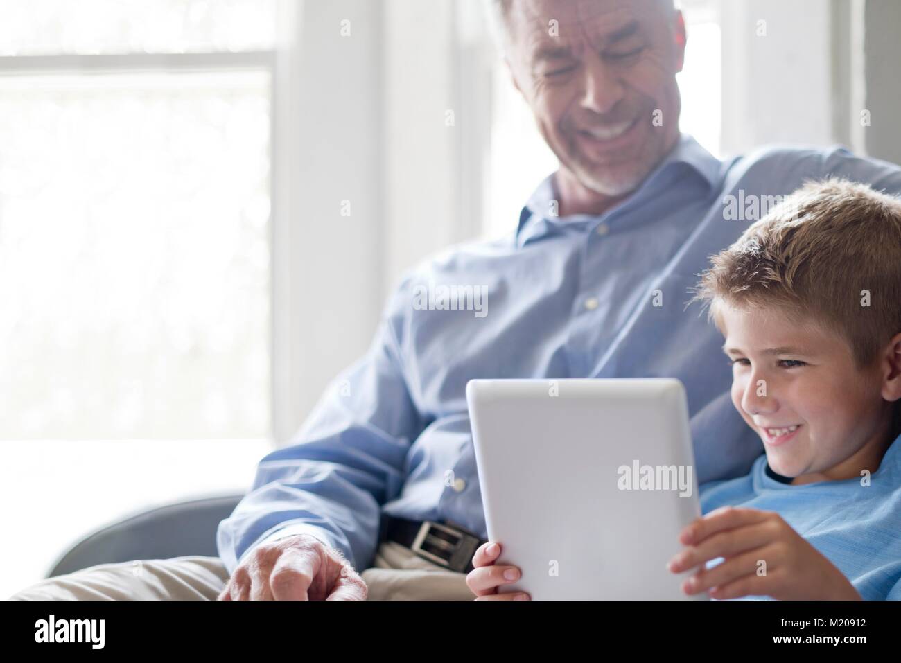 Ragazzo con tavoletta digitale con il nonno. Foto Stock