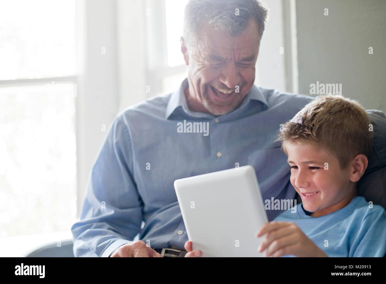 Ragazzo con tavoletta digitale con il nonno. Foto Stock