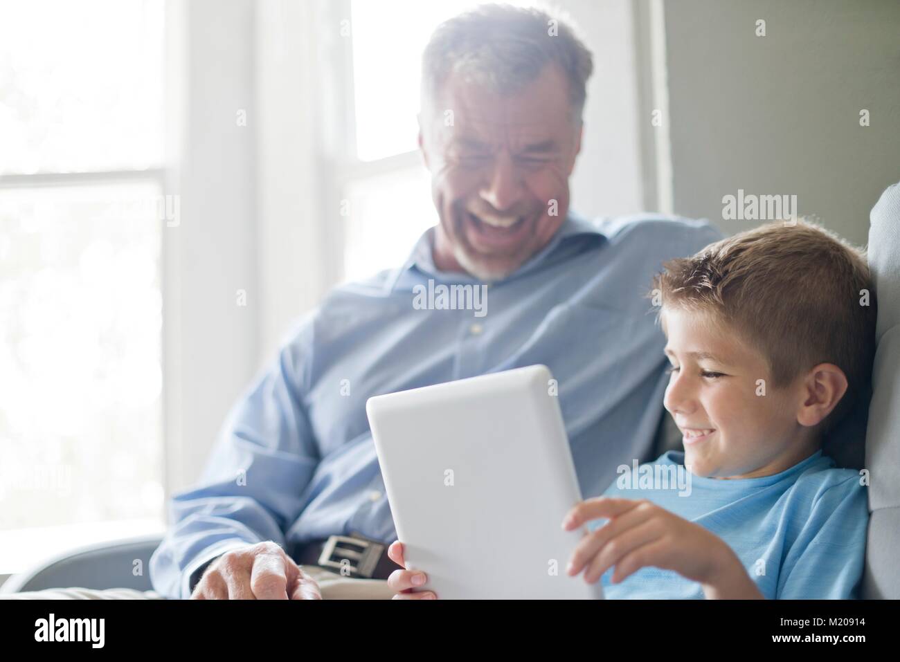 Ragazzo con tavoletta digitale con il nonno. Foto Stock