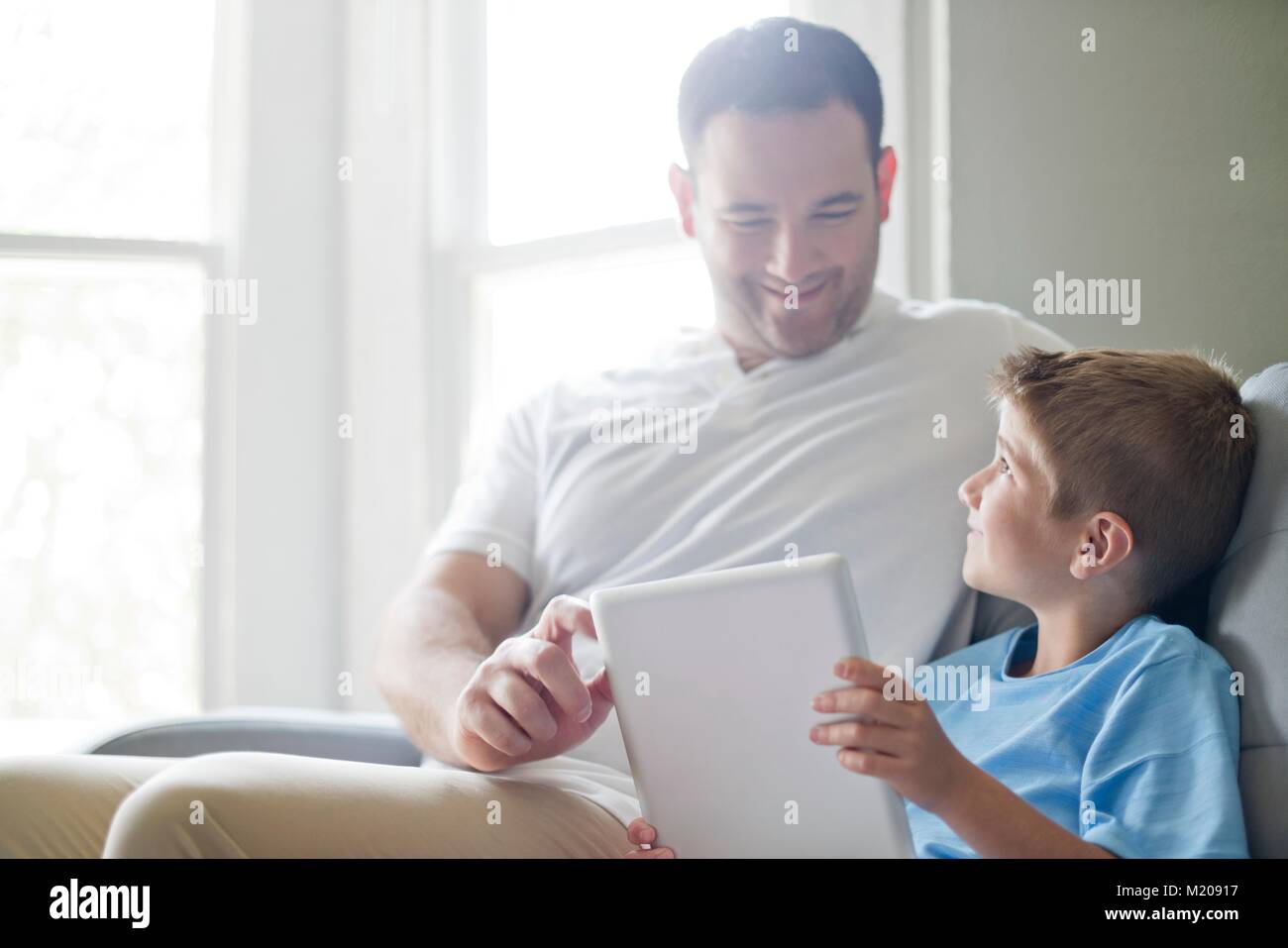 Ragazzo con tavoletta digitale con suo padre. Foto Stock