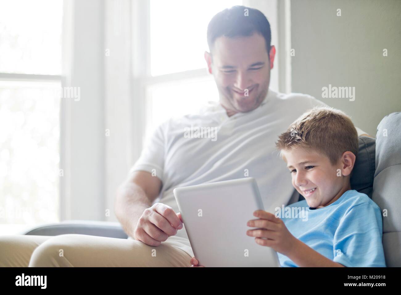 Ragazzo con tavoletta digitale con suo padre. Foto Stock