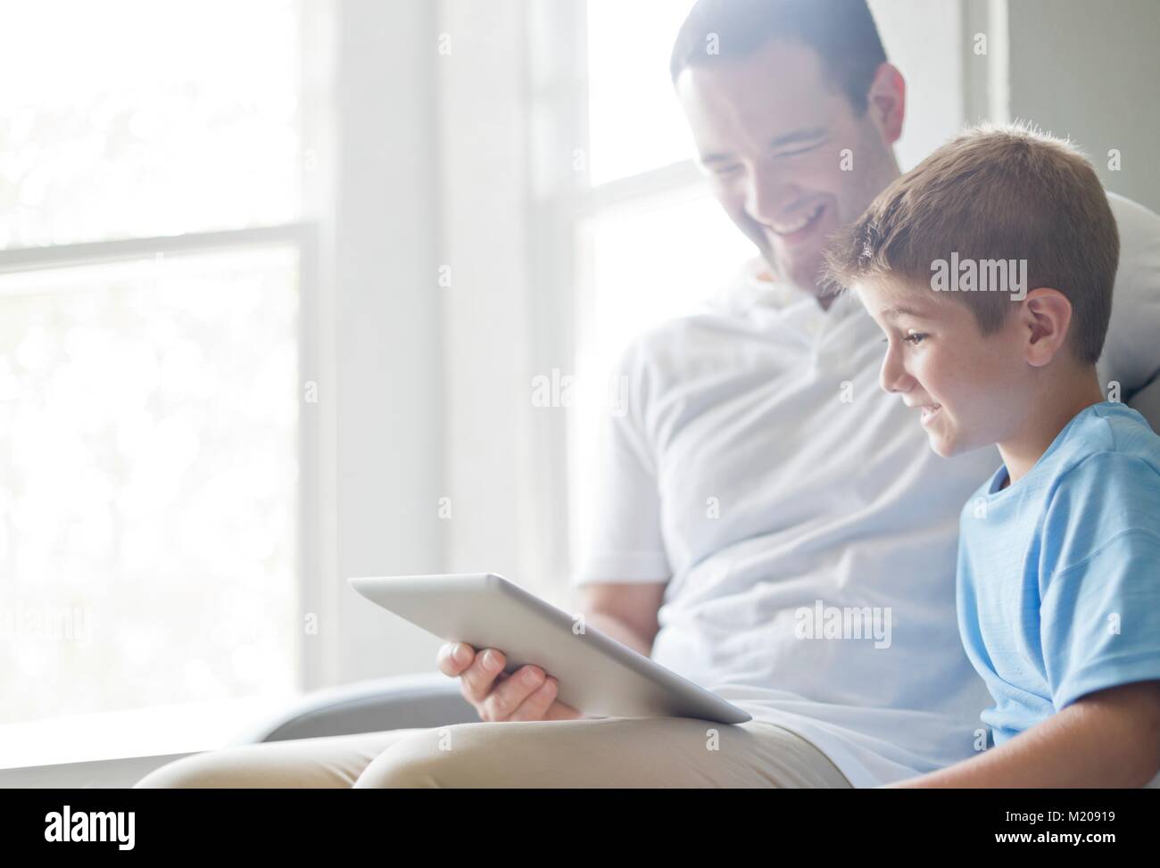 Ragazzo con tavoletta digitale con suo padre. Foto Stock