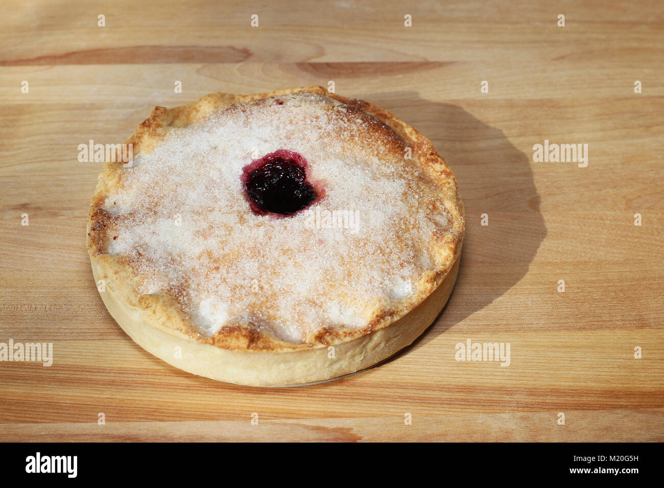 Torta ai mirtilli cosparsa di zucchero su legno spianatoia Foto Stock