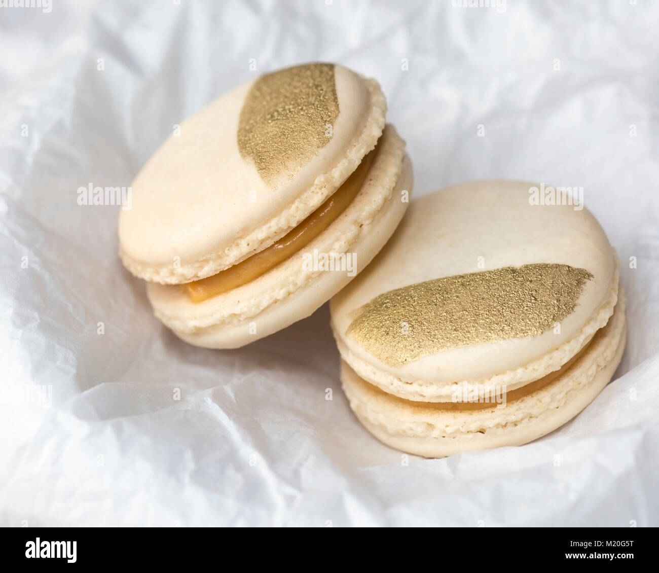 Macaron al caramello salato con decorazione in oro in carta tissue bianca  Foto stock - Alamy