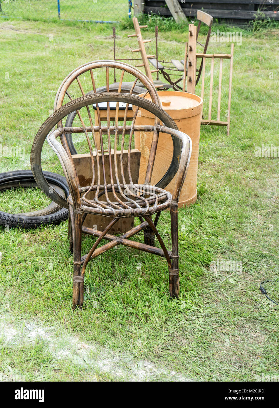 Sedia in vimini, attrezzi da giardino e pneumatici di biciclette un mercato delle pulci Foto Stock