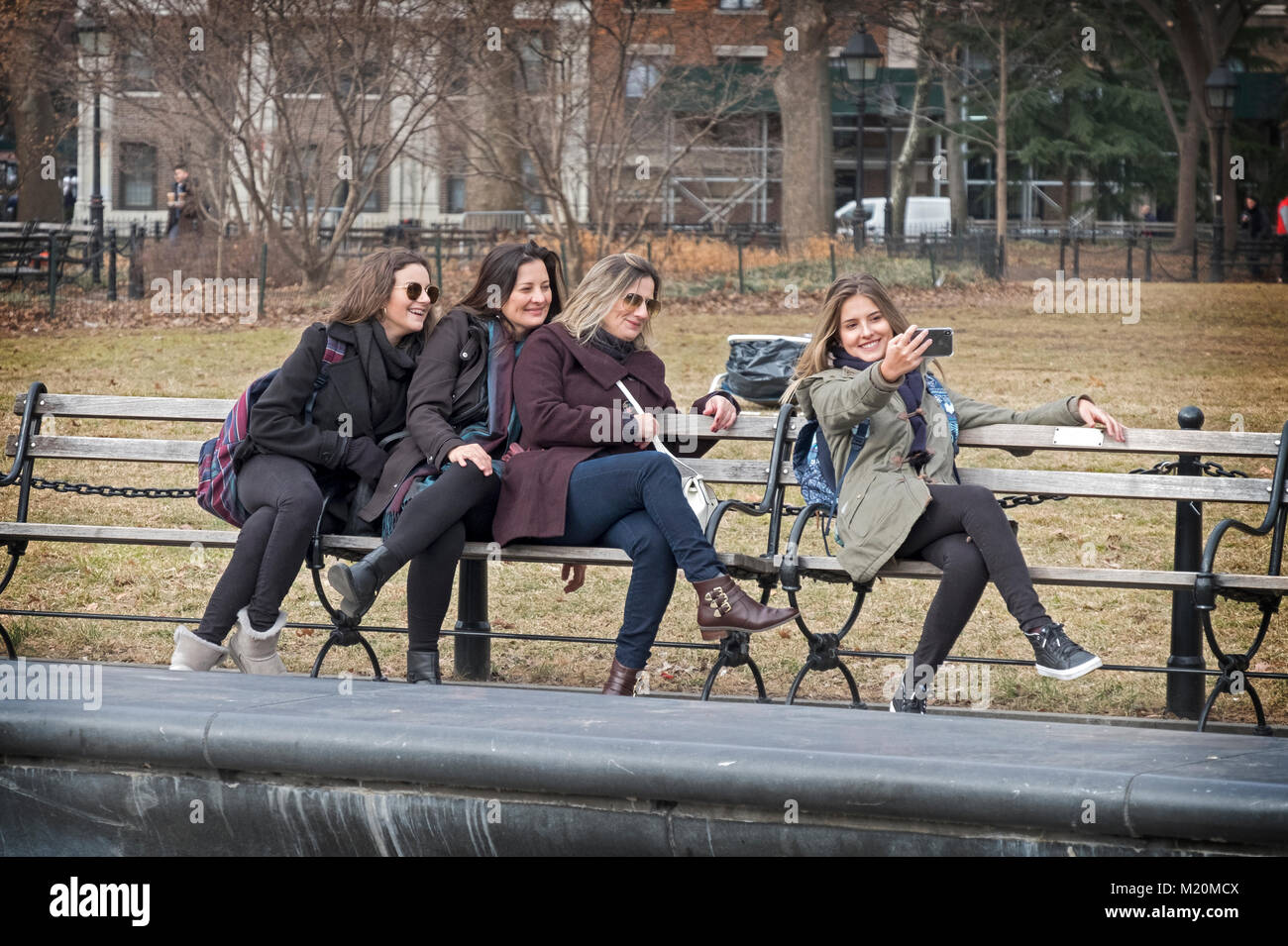Un gruppo di donne, forse una famiglia, colpire un inconsueto rappresentare per selfies in Washington Square Park nel Greenwich Village, Manhattan, New York Foto Stock