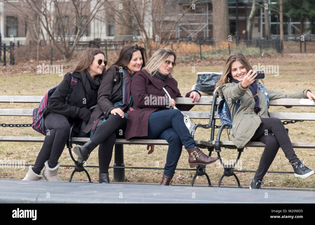 Un gruppo di donne, forse una famiglia, colpire un inconsueto rappresentare per selfies in Washington Square Park nel Greenwich Village, Manhattan, New York Foto Stock