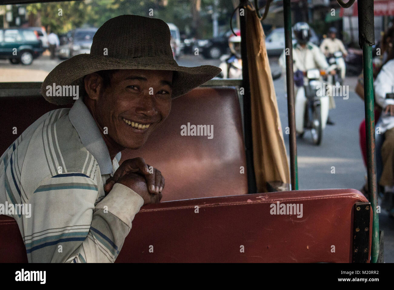 Ritratto di un uomo sorridente nel suo tuktuk in Cambogia - Foto Stock