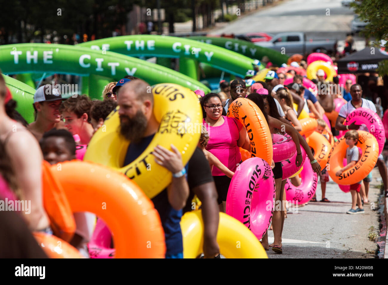 Atlanta, GA, Stati Uniti d'America - 15 Luglio 2017: centinaia di persone portano innertube galleggianti come si ottiene in linea per partecipare a far scorrere la città di Atlanta, GA. Foto Stock