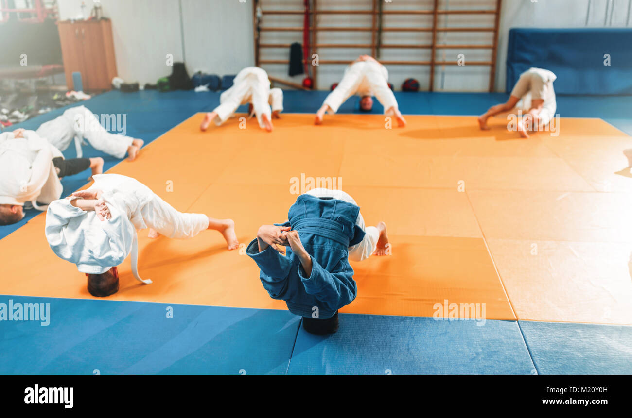 Bambini judo, kids in kimono pratica delle arti marziali di hall. Bambini e bambine in uniforme sulla formazione sportiva Foto Stock