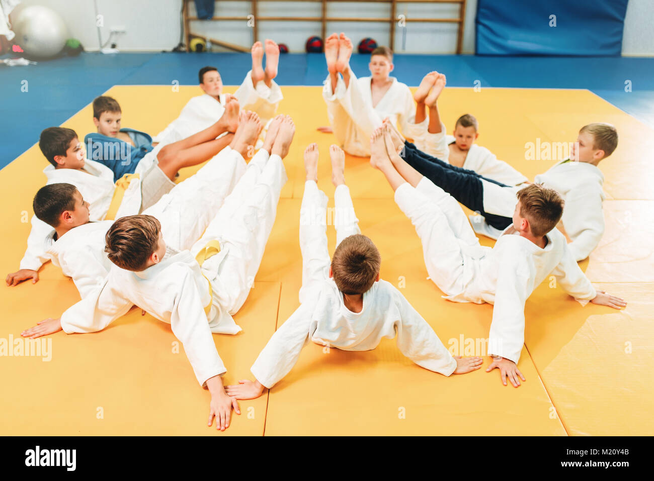 I ragazzi in kimono di formazione sul pavimento, kid judo. I giovani combattenti in palestra, arte marziale per la difesa Foto Stock