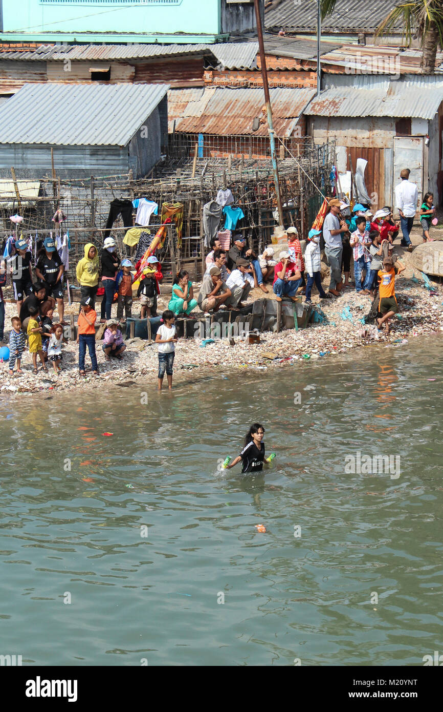 Phan Tiet, Vietnam - Gennaio 2014: gli spettatori a waterside guardando Dragon Boat Festival di corse su Ca Ty river, Phan Thiet durante il nuovo anno Foto Stock