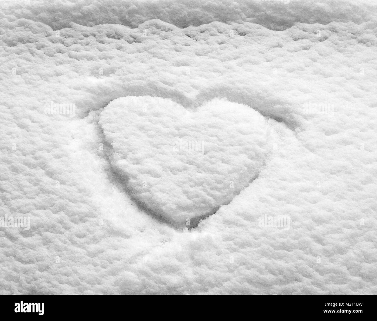 Forma di cuore annegare il bianco della neve superficie Foto Stock