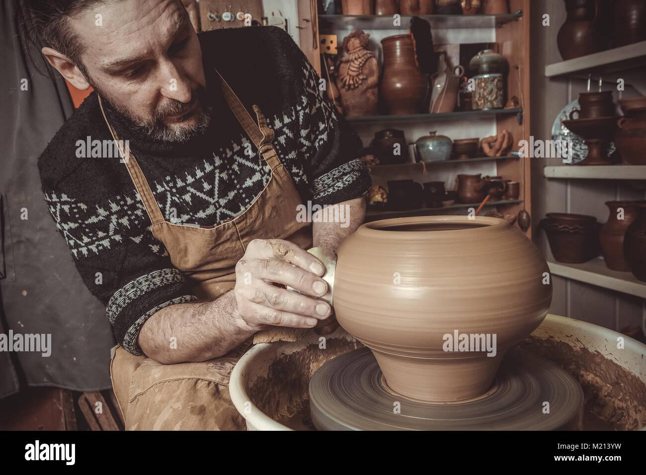 Uomo anziano rendendo pot con ruota di ceramiche in studio Foto Stock