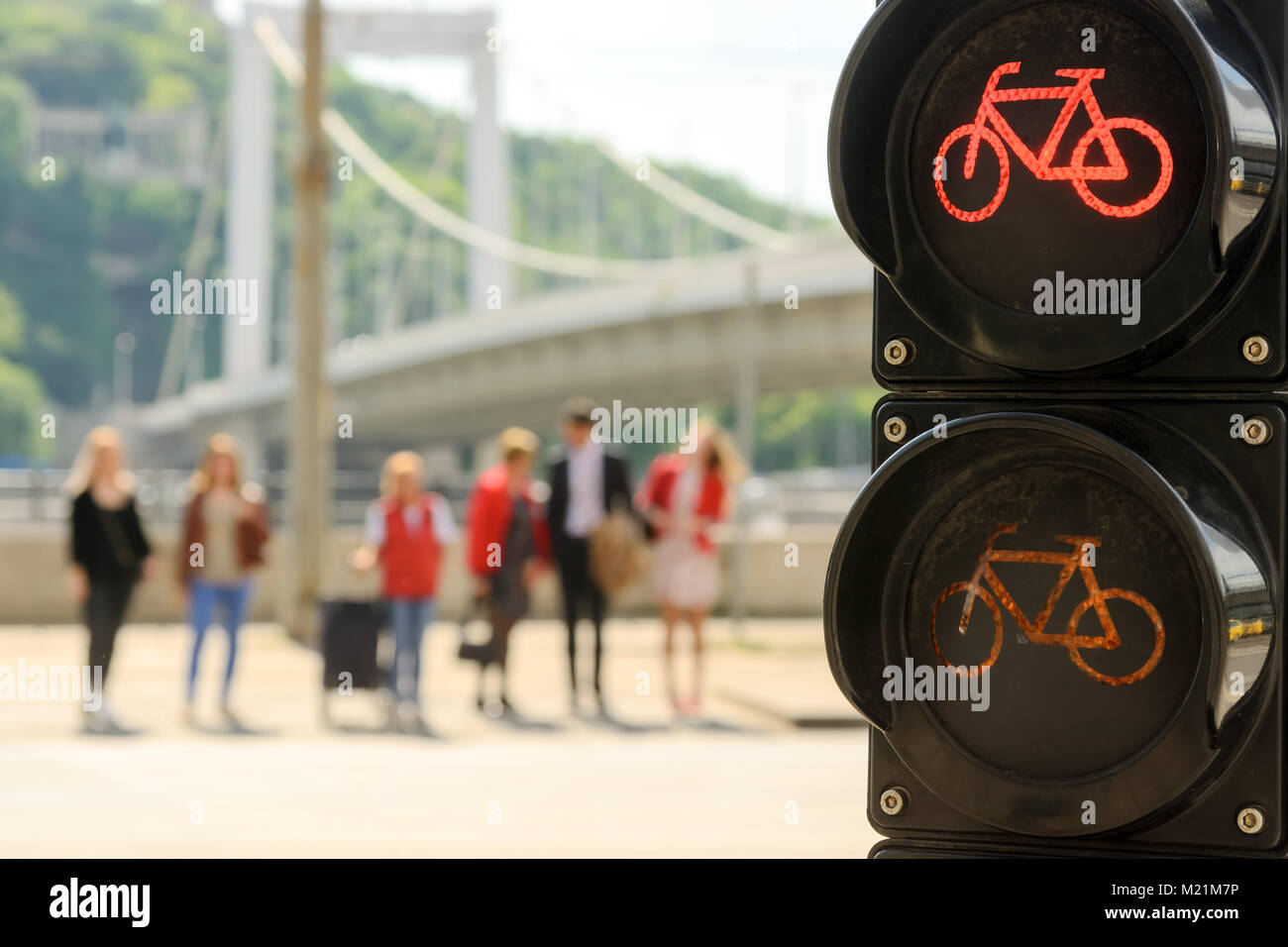 Semaforo per biciclette, offuscata la gente in piedi in linea sulla strada che attraversa Foto Stock