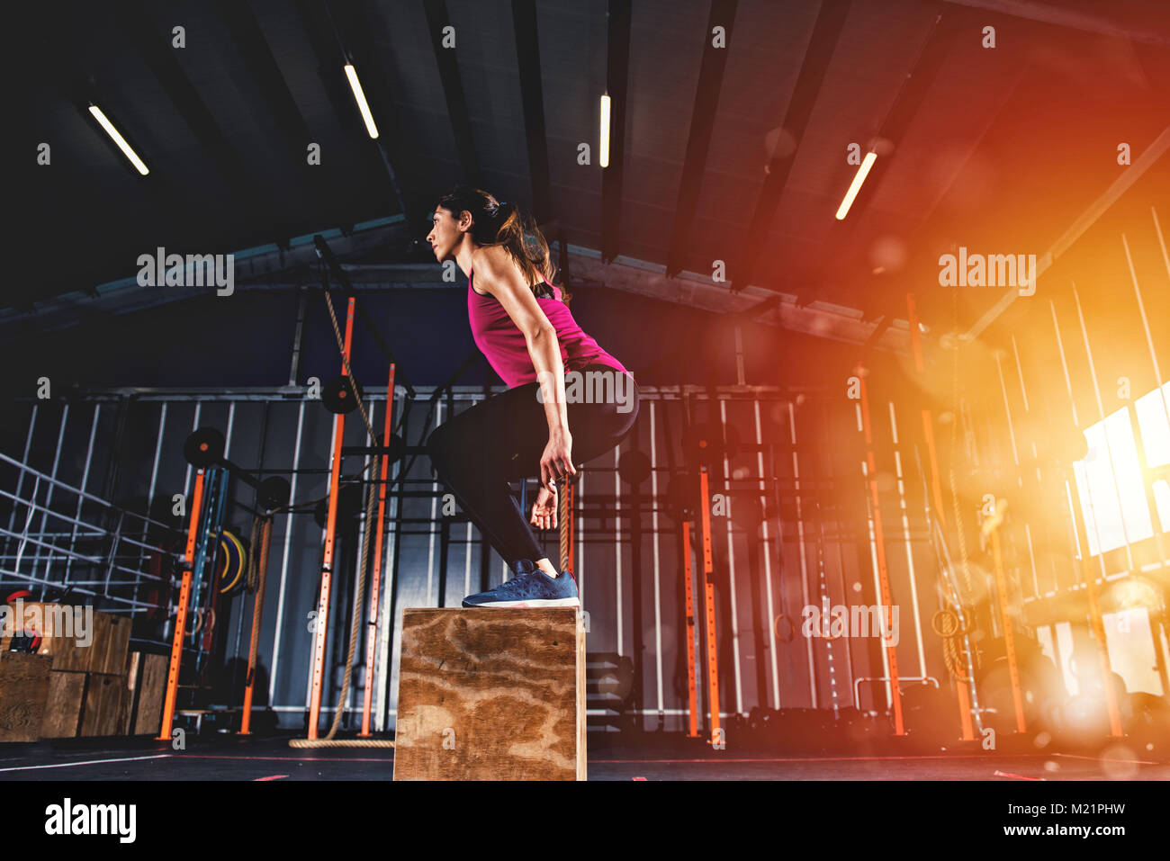 Ragazza di atletica non box jump esercizi in palestra Foto Stock