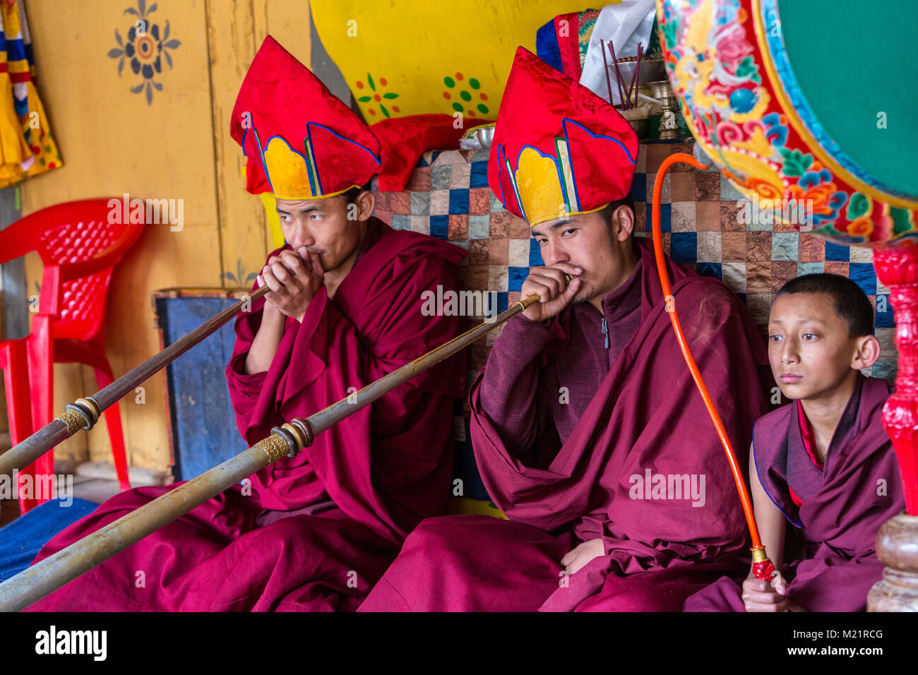 Prakhar Lhakhang, Bumthang, Bhutan. I monaci buddisti giocando il Dungchen lungo (tromba), giovane monaco suonare il tamburo. Foto Stock