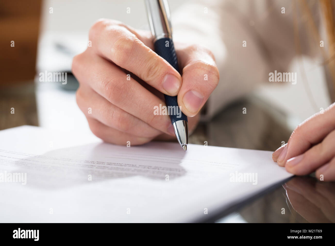 Close-up di un business persona che firma il documento con la penna sulla scrivania Foto Stock