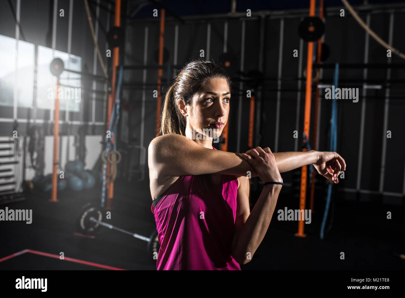 Ragazza atletica fa esercizi di stretching in palestra Foto Stock