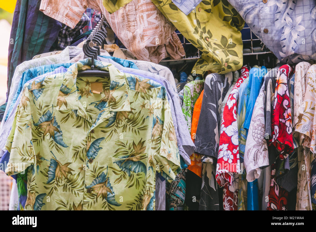 Maglietta colorata appendere sul rack al negozio di abbigliamento Foto Stock